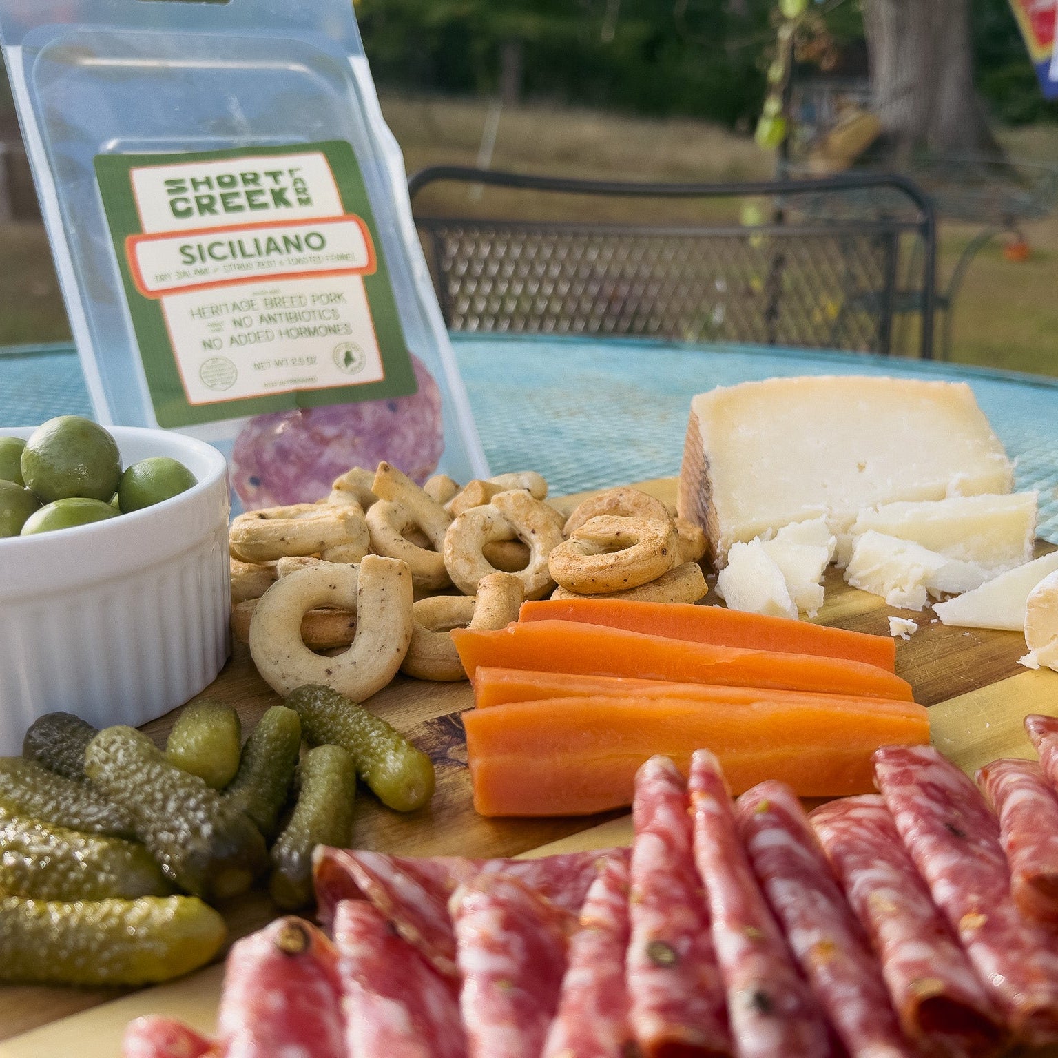 Platter of charcuterie with a 'Short Creek' Siciliano package in the background